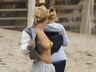 Rita Ora deixa os seios à mostra durante ensaio fotográfico na praia 