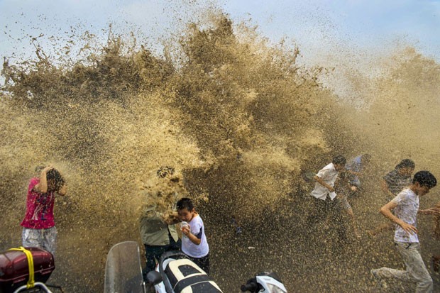 Grupo de chineses e turistas foi atingido por uma onda às margens do rio Qiantang (Foto: Reuters)