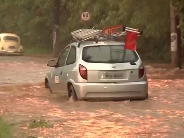 Carro passa por rua alagada em Araçatuba (Foto: Reprodução/TV TEM)