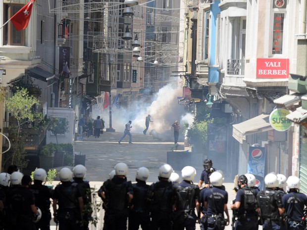 Policiais em formação tentam conter manifestantes durante protesto na Turquia neste sábado (1º). (Foto: Bulent Kilic/AFP)