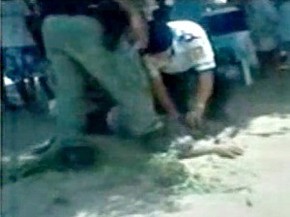 Policiais prendem a cabeça da vítima contra a areia no chão (Foto: Reprodução)