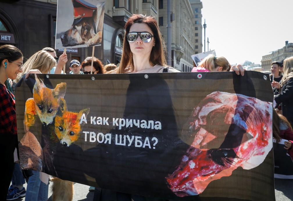 Manifestante carrega um cartaz com a frase "O que o seu casaco de pele gritou?" durante uma manifestação pelo 1º de maio nesta quarta-feira, em Moscou, na Rússia. — Foto: Tatyana Makeyeva/Reuters