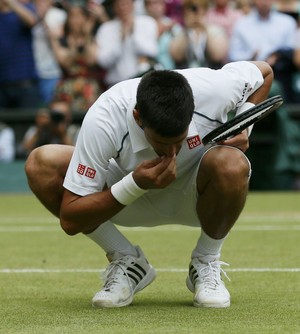Novak Djokovic come grama após fim do jogo em Wimbledon 2015 (Foto: Reuters)