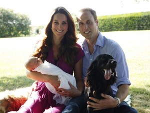 Imagem datada do começo de agosto mostra o príncipe William, a duqesa de Cambridge e o bebê George. Aparecem também na foto os cães Tilly (golden, à esquerda) e Lupo. A foto foi tirada pelo pai de Kate, no jardim da residência oficial da família Middleton (Foto: AFP)