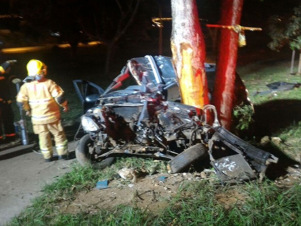 Militares do Corpo de Bombeiros durante atendimento a ocorrência em Sobradinho II, no Distrito Federal, na madrugada deste domingo (26); carro teve motor arrancado depois de capotar e bater em árvore (Foto: Corpo de Bombeiros DF/Divulgação)