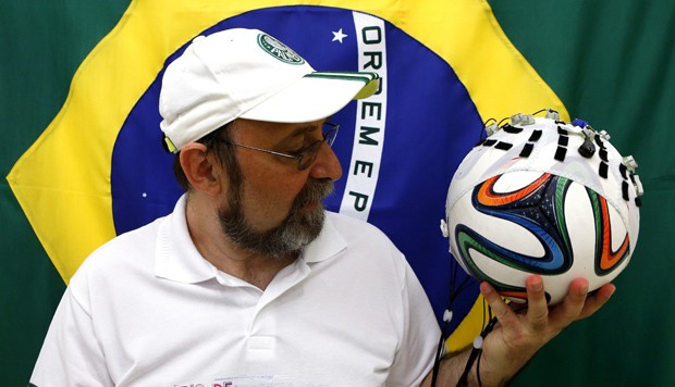 Cientista Miguel Nicolelis segura uma bola de futebol com uma toca de eletrodos nesta quarta-feira (21) (Foto: Reuters/Paulo Whitaker)