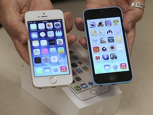 Funcionário de operadora de telefonia mostra visores do iPhone 5S e do iPhone 5C em loja de Utah, nos Estados Unidos, na quinta-feira (19) (Foto: George Frey/Reuters)