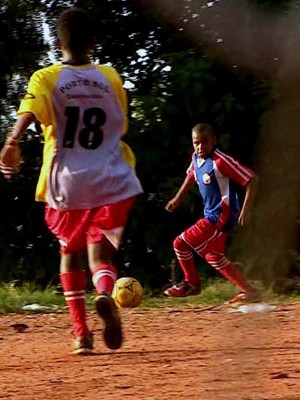 Meninos jogam futebol em campo improvisado (Foto: Reprodução/RBS TV)
