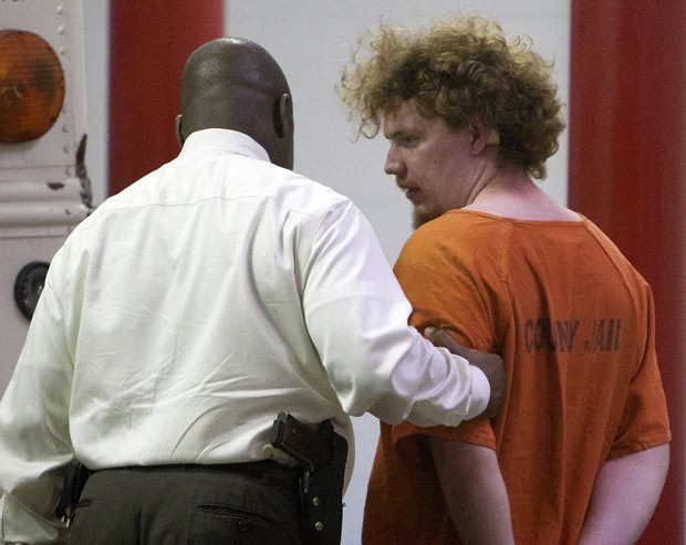 Dylan Quick, à direita, é levado após ser interrogado por policias nesta terça-feira (9) em Houston (Foto: AP)