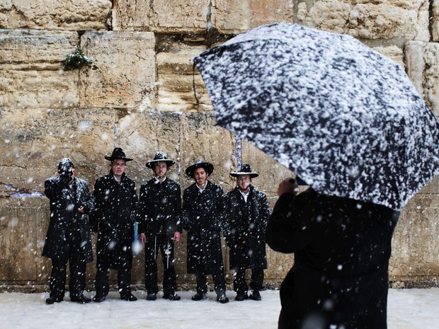 Judeus posam para foto debaixo de neve no Muro das Lamentações. (Foto: Bernat Armangue/AP)