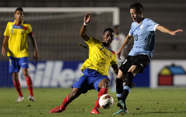 López, do Uruguai, e Gruezo, do Equador, disputam a bola durante o jogo (Foto: AFP)