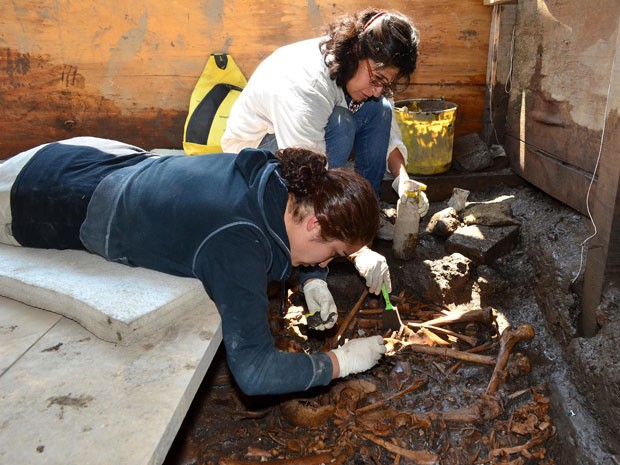 Arqueólogas trabalham na escavação dos esqueletos no México (Foto: AFP)