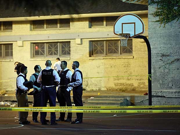 Polícia isola quadra de basquete do Cornell Square Park, em Chicago, onde várias pessoas foram baleadas. (Foto: Scott Olson / Getty Images / AFP Photo)