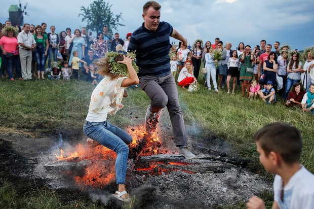 Casal se atrapalhou ao tentar saltar sobre fogueira durante as celebrações do tradicional feriado de Ivana Kupala (Foto: Gleb Garanich/Reuters)