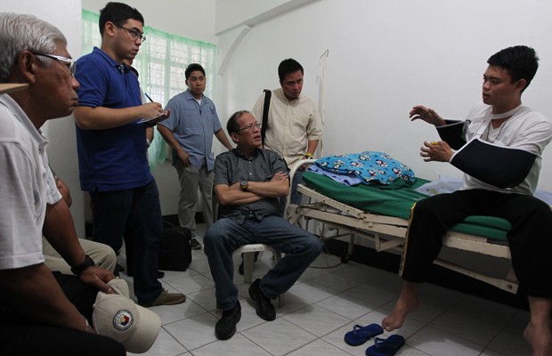 O preidente das Filipinas, Benigno Aquino III, conversa com Jun Abrazado, que sobreviveu a queda (Foto: AP Photo/Malacanang Photo Bureau, Jay Morales)