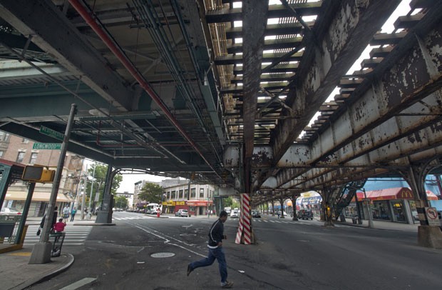 Homem passa por baixo de trilhos do trem que cruzam o Bronx, em Nova York. Empresa oferecia passeios a turistas e, segundo moradores, denegriam a imagem do bairro (Foto: AP)