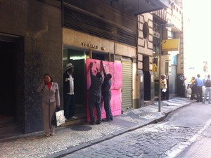 Funcionários colocam tapumes na fachada de prédio na Rua Álvaro Alvim, próximo à Câmara do Rio, nesta quinta-feira (22) (Foto: Mariucha Machado/G1)