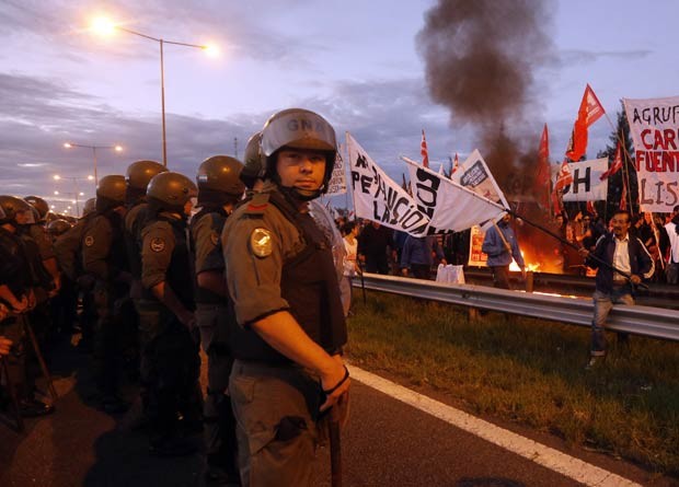 Manifestantes protestam em frente à barreira policial, bloqueando uma rodovia em Buenos Aires durante a greve nacional (Foto: Enrique Marcarian/Reuters)