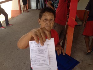  Maria Gomes, de 56 anos, com o exame para consulta médica (Foto: John Pacheco/G1)