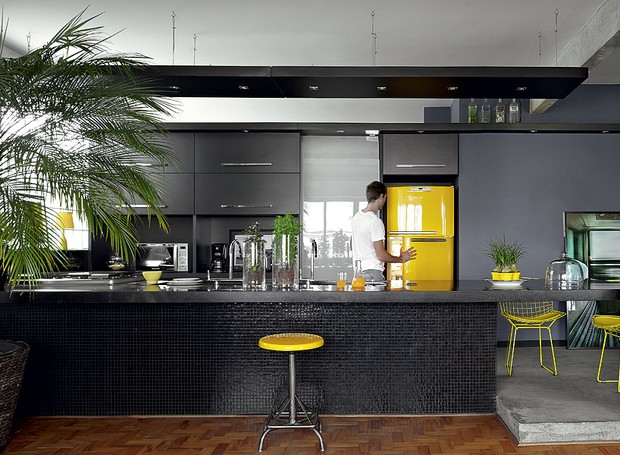 “Amarelo me faz bem.” É com essa frase que o arquiteto Diogo Oliva olha para sua geladeira e justifica a escolha do tom. A cozinha teria tudo para ser sisuda: marcenaria e pastilhas pretas, cimento queimado. Mas ali está a cor (Foto: Victor Affaro/Casa e Jardim) “Amarelo me faz bem.” É com essa frase que o arquiteto Diogo Oliva olha para sua geladeira e justifica a escolha do tom. A cozinha teria tudo para ser sisuda: marcenaria e pastilhas pretas, cimento queimado. Mas ali está a cor (Foto: Victor Affaro/Casa e Jardim)