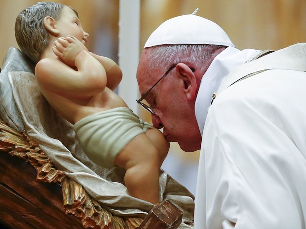 O Papa Francisco beija a imagem do menino Jesus durante Missa de Natal na Basílica de São Pedro, no Vaticano, na quinta (24) (Foto: Reuters/Tony Gentile)