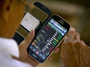 Investidor usa smartphone para monitorar ações na China (Foto: Mark Schiefelbein / AP Photo)