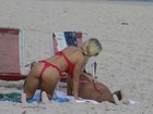 Ops! Caren Souza e Thaiz Schmitt ajeitam biquíni na praia