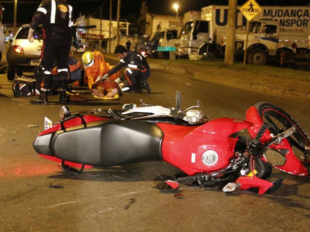 Bombeiros socorrem motociclista que se envolveu em batida no DF; à frente, veículo caído ao chão (Foto: Corpo de Bombeiros DF/Divulgação)