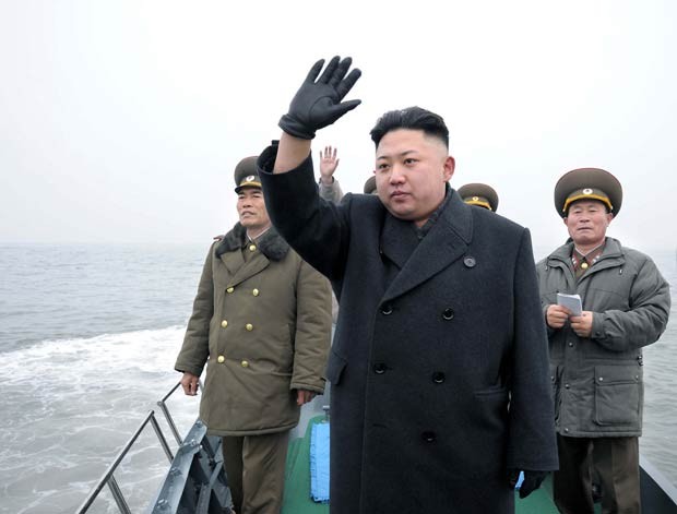 O ditador da coreia do Norte, Kim Jong-un, acena para soldados em um barco durante inspeção de instalações militares próximo à ilha de Taeyonphyong, em foto divulgada nesta quinta-feira (7) (Foto: AFP)