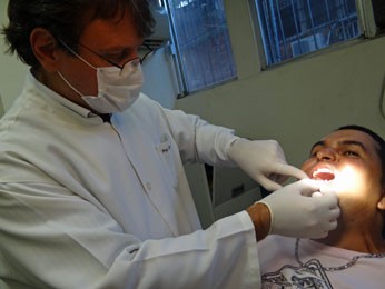 Leandro Araújo sendo examinado pelo dentista Ricardo Eugenio (Foto: Priscila Miranda / G1)