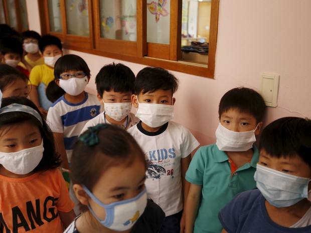 Crianças usam máscaras para evitar a Síndrome Respiratória Médio Oriente (MERS) em uma escola primária em Seul, na Coreia do Sul. O Ministério da Saúde do país confirmou oito novos casos da doença, elevando o número para 95  (Foto: Kim Hong-Ji/Reuters)