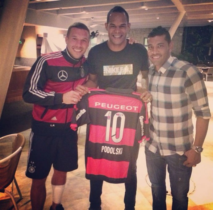 Podolski com André Santos mostra camisa do Flamengo