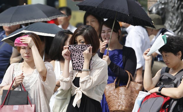 Moradores enfrentam calor na tarde desta sexta-feira (12) em Tóquio, capital do Japão (Foto: AP)