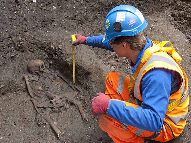 Arqueólogo faz medições de esqueleto encontrado no centro de Londres (Foto: Crossrail/AFP)