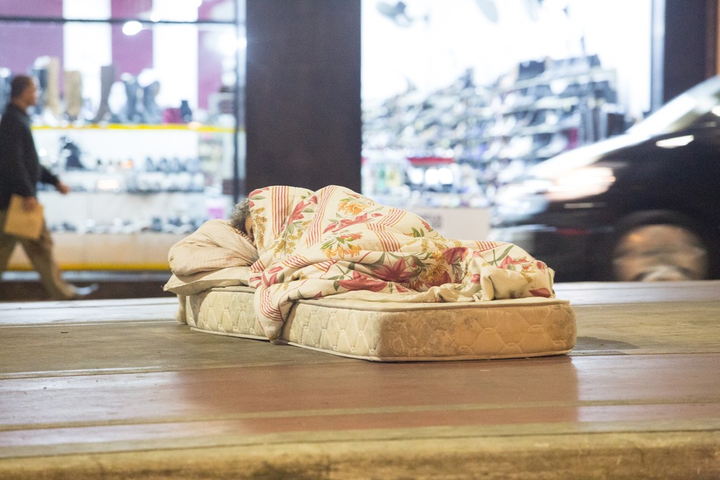 Morador de rua dorme coberto na Avenida General Olímpio da Silveira, perto da estação de metrô Santa Cecília (Foto: Celso Tavares/G1)