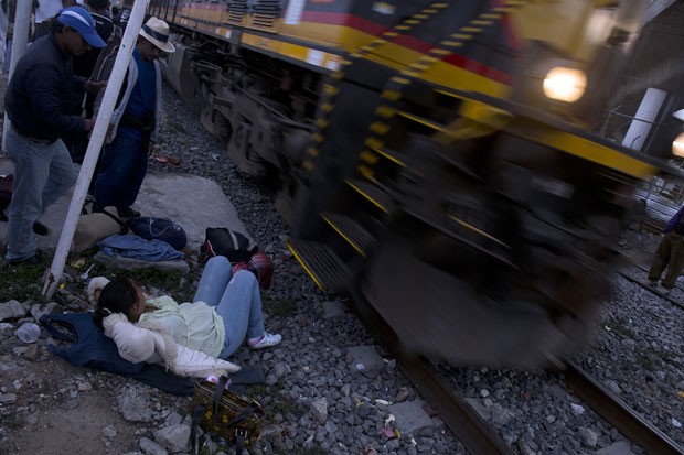 Trem passa rente a mulher deitada ao lado dos trilhos em Lechería (Foto: Yuri Cortez/AFP)