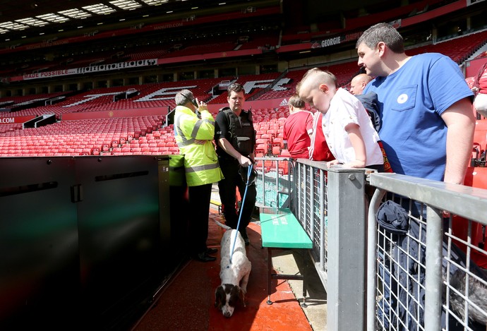 Policial com cachorro inspeciona estádio Old Trafford antes do jogo do Manchester United (Foto: Martin Rickett/PA / PA via AP)