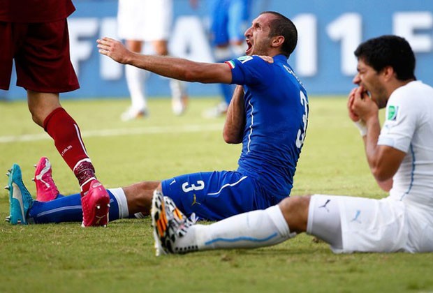Chiellini reclama de dor no ombro, enquanto Suárez coloca as mãos no dente (Foto: Reuters)