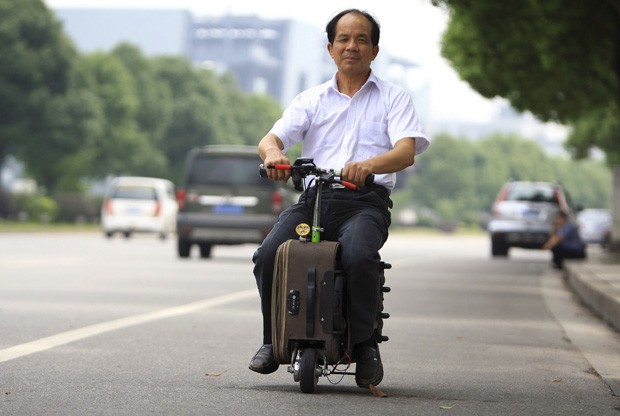 He Liang anda com sua mala motorizada pelas ruas de Changsha, na China (Foto: China Daily/Reuters)