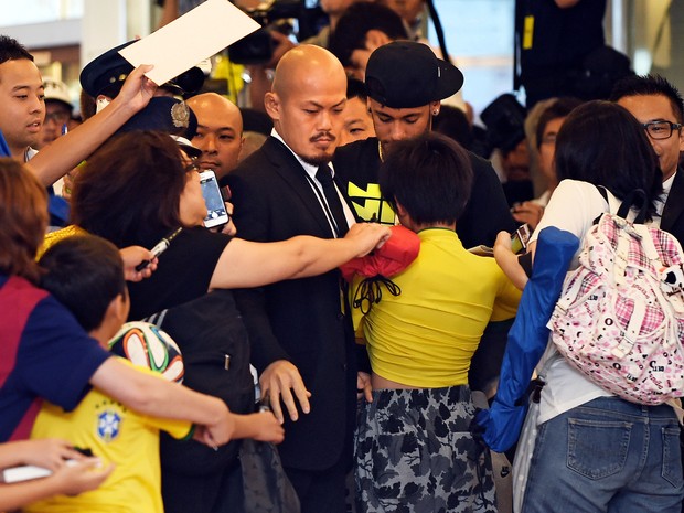 Neymar é cercado por fãs em aeroporto em Tóquio, no Japão (Foto: Toshifumi Kitamura/ AFP)
