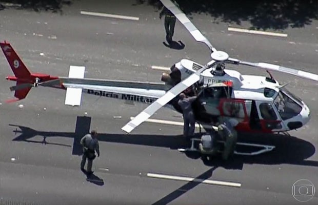 Técnicos fazem manutenção no helicóptero da Polícia Militar (Foto: TV Globo/Reprodução)