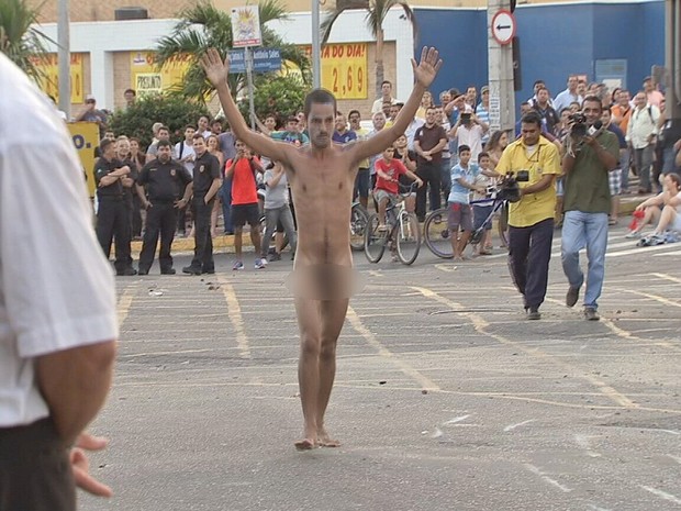 Manifestante de braços erguidos se aproximou da polícia e foi detido (Foto: TV Verdes Mares/Reprodução)