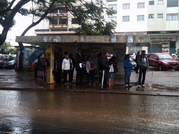 Passageiros esperam ônibus em parada durante chuva nesta terça-feira  (Foto: Raquel Morais/ G1)