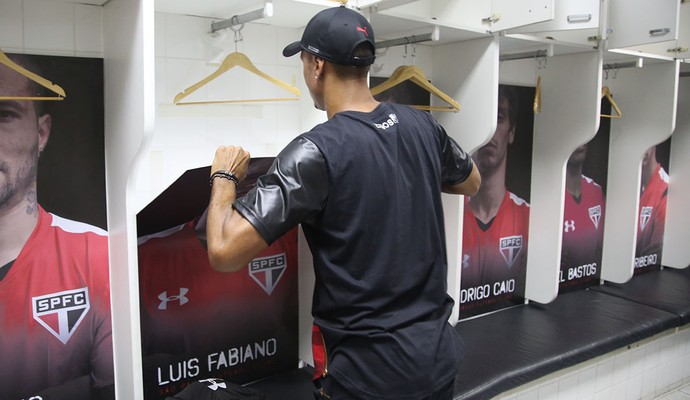 Luis Fabiano retira pôster de seu espaço no vestiário do São Paulo (Foto: Rubens Chiri / saopaulofc.net)