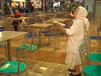 Isaura Lima Lopes lê a bíblia no saguão do aeroporto (Foto: Reprodução/RBS TV)