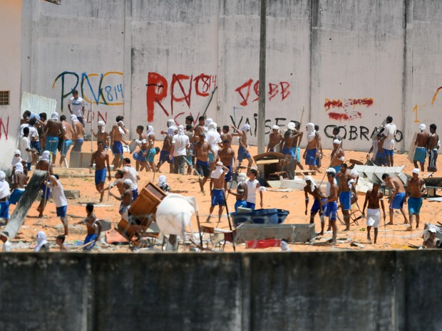 Presos são vistos durante um confronto de facções na penitenciária de Alcaçuz, perto de Natal, no Rio Grande do Norte (Foto: Andressa Anholete/AFP)