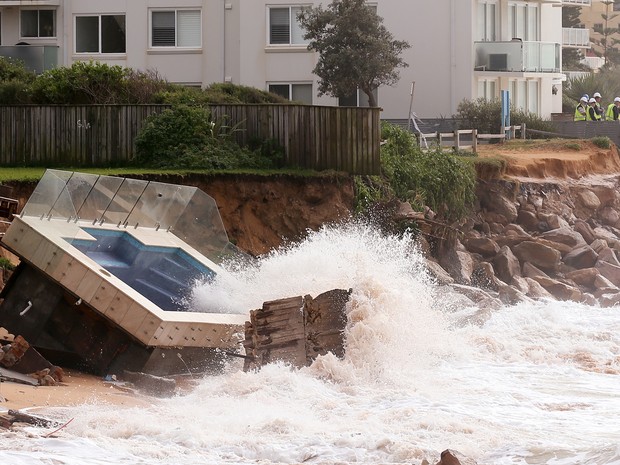 forte onda do fim de semana causou erosão de cerca 50 metros de costa e danificou dezenas de casas. Piscina foi parar em praia (Foto: Rick Rycroft/AP)