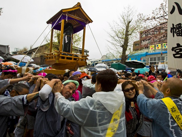 Japoneses carregam a estátua de um pênis durante o festival Kanamara Matsuri neste domigo (5) em Kawasaki, cidade na província de Kanagawa, no Japão (Foto: REUTERS/Thomas Peter)