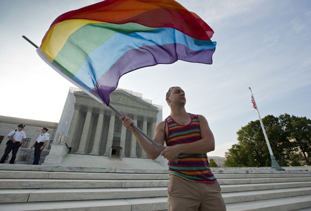 Defensor do casamento gay empunha bandeira na frente da Suprema Corte nesta quarta (26) em Washington (Foto: J. Scott Applewhite/AP)