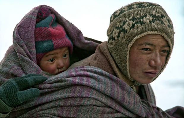 O momento em que a mãe leva o recém-nascido nas costas de volta para casa, numa jornada de 70km a pé, na Índia (Foto: Tim Vollmer/Caters News)